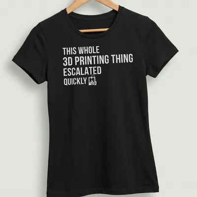 Bold text design reading 'THIS WHOLE 3D PRINTING THING ESCALATED QUICKLY' on gray background — printed on a women's shirt