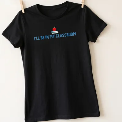 Playful illustration of an apple and books with the text I'll Be In My Classroom — printed on a women's shirt