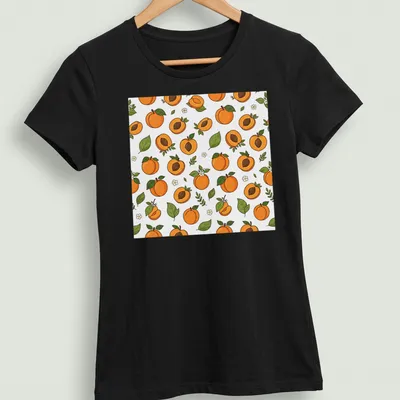 Seamless pattern featuring illustrated apricot fruit in orange and green. — printed on a women's shirt