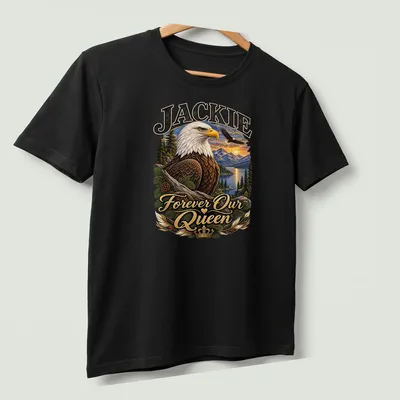 Realistic print of a bald eagle with text 'Jackie Forever Our Queen' in rich colors — printed on a unisex t-shirt (angled view)