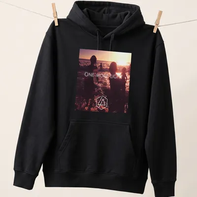 Photographic print of beach silhouettes with 'ONE MORE LIGHT' text in sunset colors. — printed on a unisex hoodie