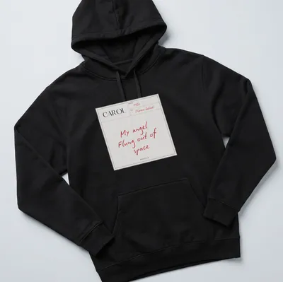 Minimalist t-shirt featuring white text saying 'My angel Flung out of space' on a red background — printed on a unisex hoodie