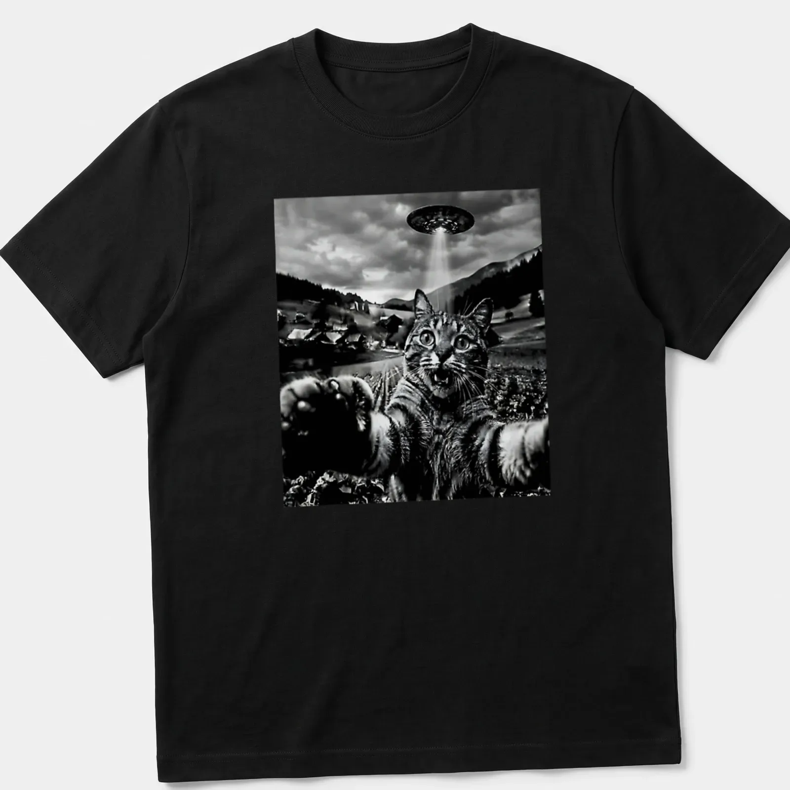 Retro graphic of a cat taking a selfie in front of a UFO in black, white, and gray — printed on a unisex t-shirt