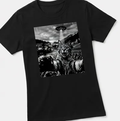 Retro graphic of a cat taking a selfie in front of a UFO in black, white, and gray — printed on a women's shirt