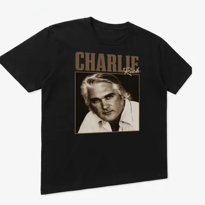 Vintage-style Charlie Rich t-shirt with classic lettering in warm tones — printed on a unisex t-shirt (angled view)