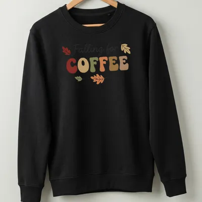 Playful typography t-shirt featuring coffee and colorful autumn leaves — printed on a unisex sweatshirt