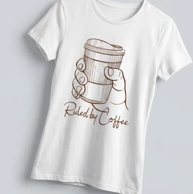 Line art of a hand holding a coffee cup with text 'Ruled by Coffee' in brown and white — printed on a women's shirt