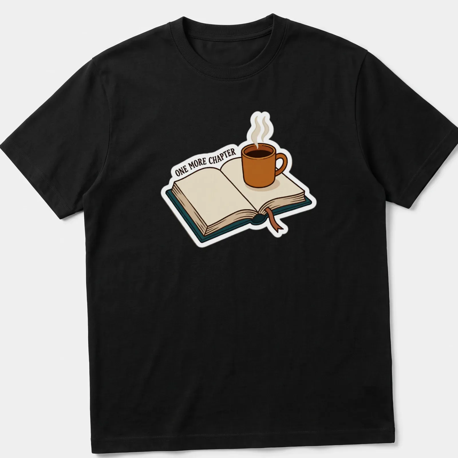 Cartoon design featuring a coffee mug and open book with the text 'ONE MORE CHAPTER' — printed on a unisex t-shirt