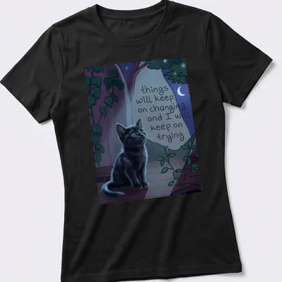 Whimsical illustration of a black cat with a motivational quote among nighttime colors — printed on a women's shirt