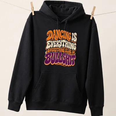 Retro style T-shirt with bold text about dancing in orange, cream, purple, and white — printed on a unisex hoodie