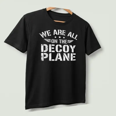 Distressed t-shirt with the phrase 'We Are All On The Decoy Plane' in white — printed on a unisex t-shirt (angled view)