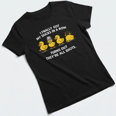 Cartoon ducks humorously illustrated, with text about getting ducks in a row. — printed on a women's shirt