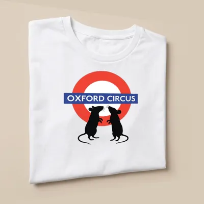 Whimsical graphic of fighting mice with Oxford Circus text above in red, blue, black, and white. — printed on a unisex t-shirt (angled view)