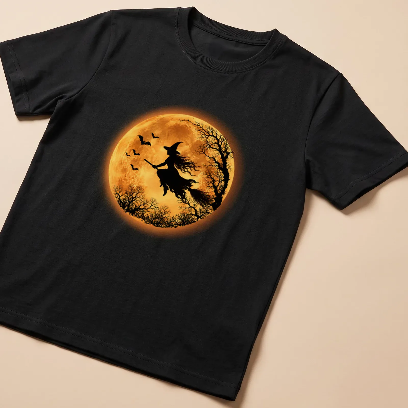 Silhouette of a flying witch against a full moon in black, orange, and yellow — printed on a unisex t-shirt