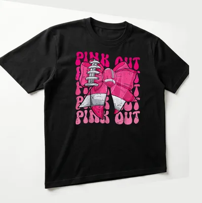 Bold graphic of a football bow with 'PINK OUT' text for breast cancer awareness — printed on a unisex t-shirt (angled view)