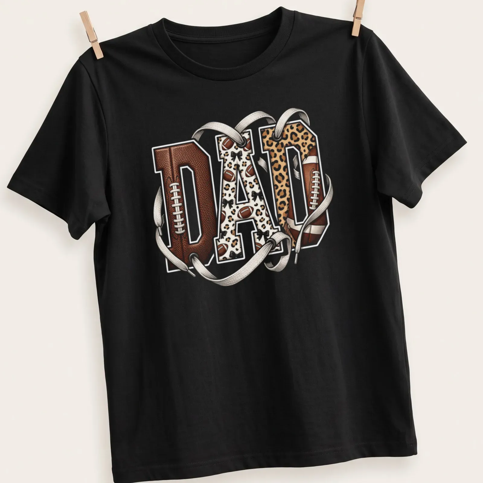 Leopard print typography spelling out DAD with a football theme — printed on a unisex t-shirt