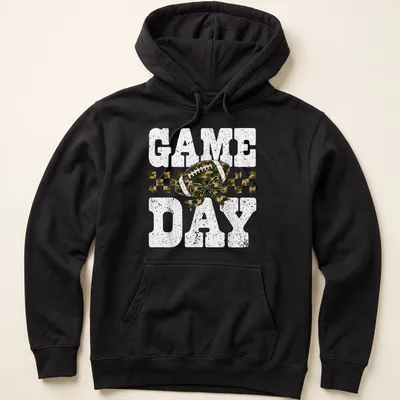 Camo print shirt with playful football and bow graphic, text reads 'GAME DAY' — printed on a unisex hoodie
