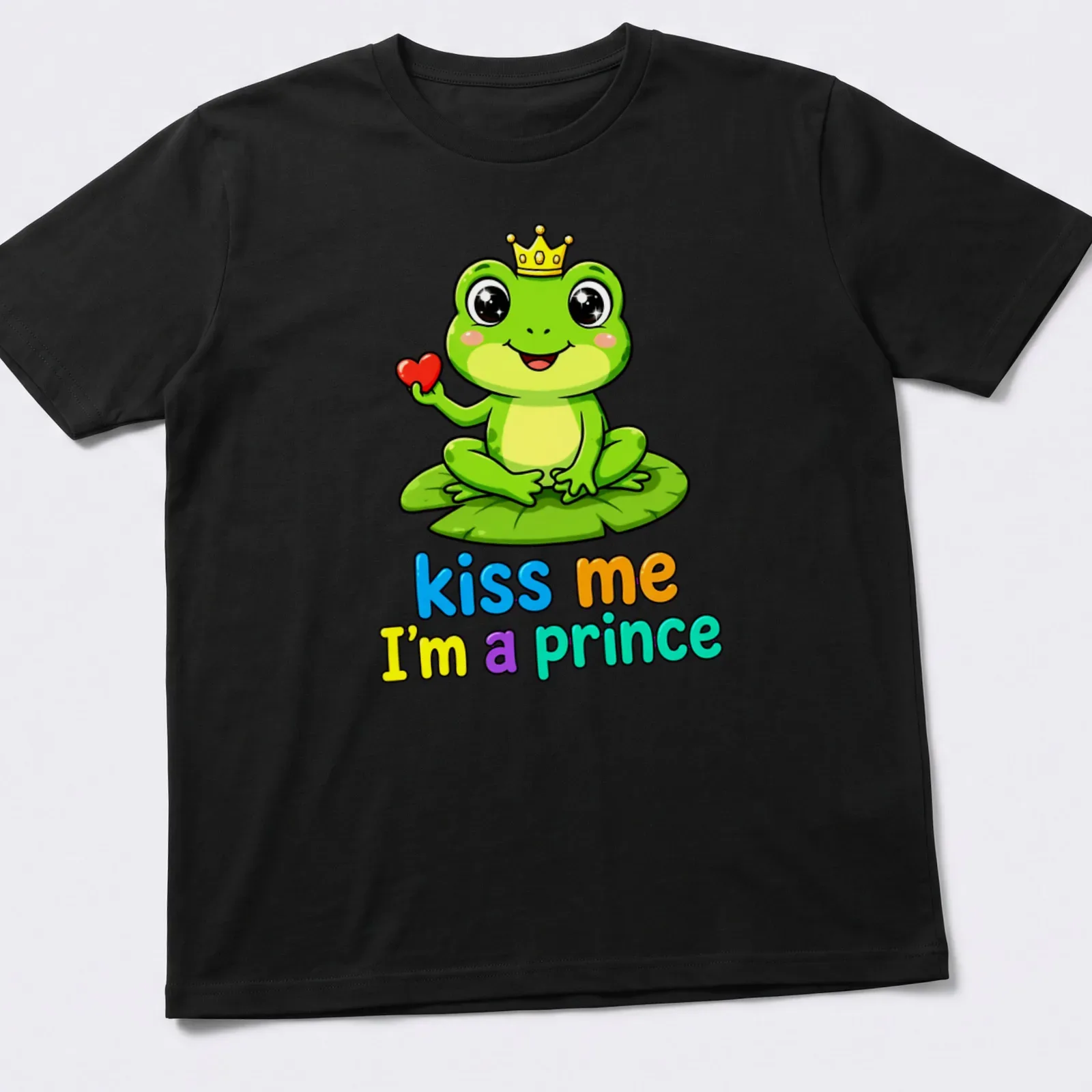 Kawaii frog prince on lily pad with colorful text "kiss me I'm a prince" — printed on a unisex t-shirt