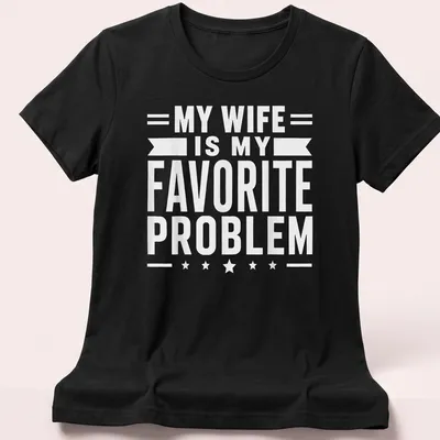 Bold typography t-shirt stating 'MY WIFE IS MY FAVORITE PROBLEM' in white — printed on a women's shirt