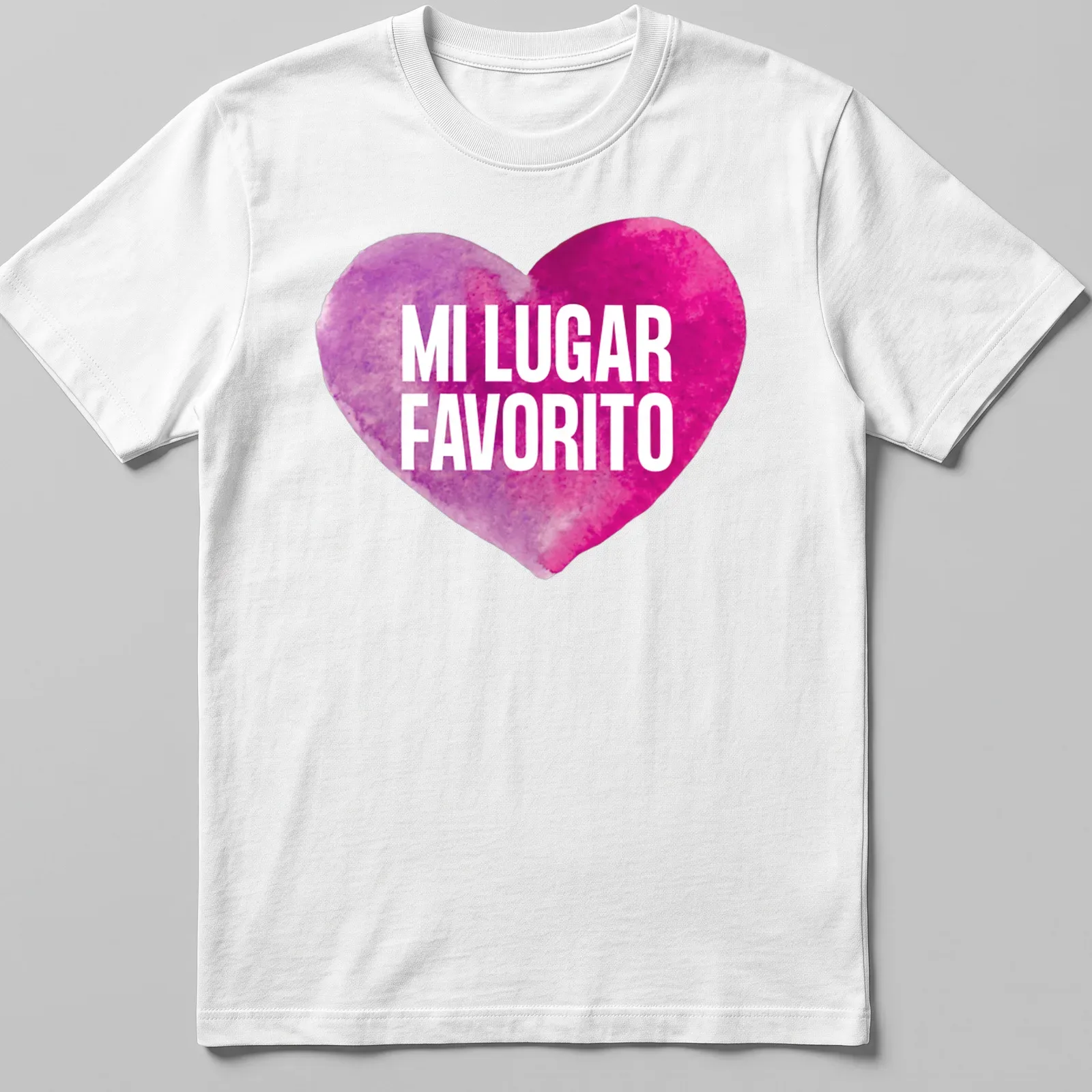 Watercolor heart graphic with the words 'MI LUGAR FAVORITO' in pink and purple — printed on a unisex t-shirt