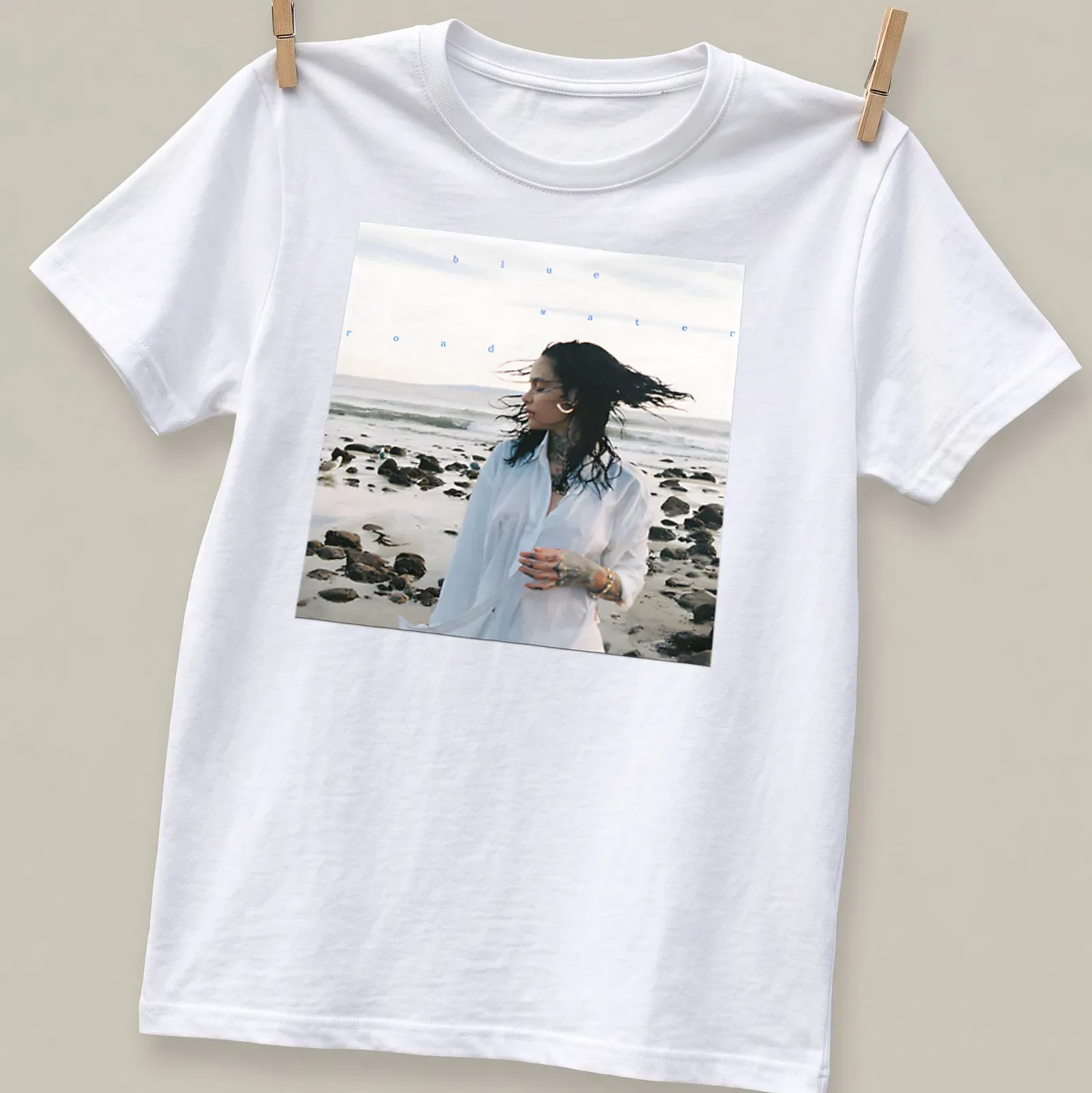 Photographic print of a woman by the beach with text 'blue water road' in blue and white — printed on a unisex t-shirt
