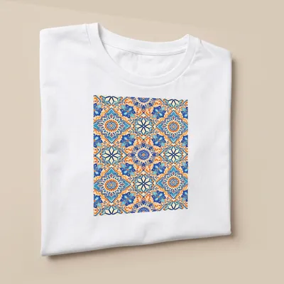 Vibrant geometric ornamental mosaic design in blue and orange — printed on a unisex t-shirt (angled view)