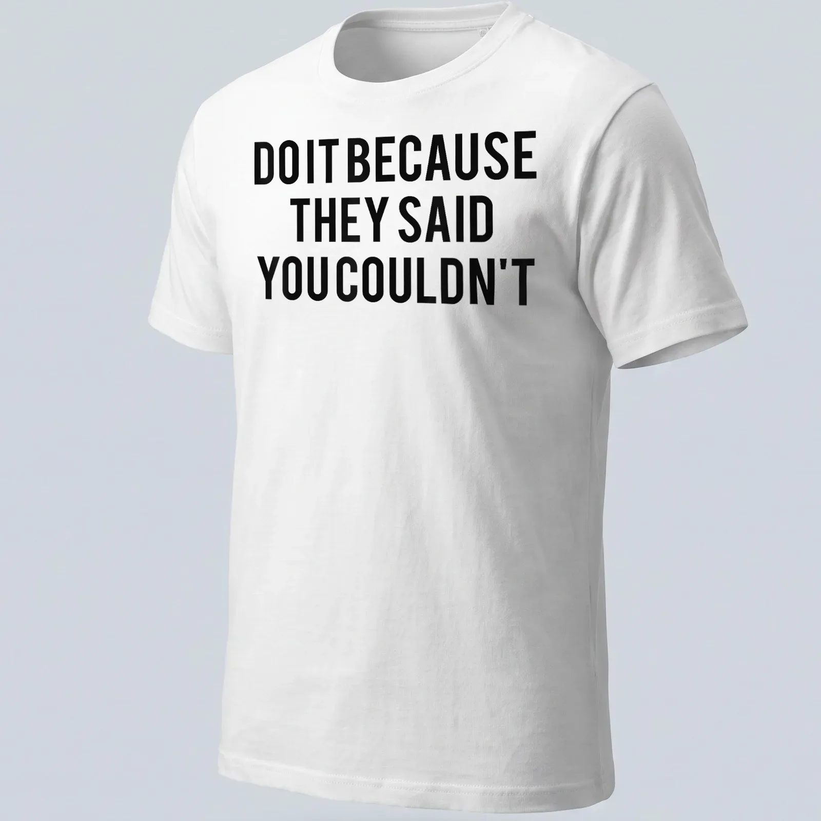 Bold typography shirt with the motivational quote 'DO IT BECAUSE THEY SAID YOU COULDN'T' in black and white — printed on a unisex t-shirt
