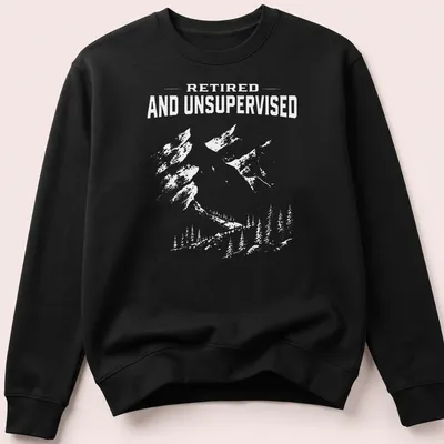 Vintage distressed tee featuring mountains and the phrase Retired And Unsupervised — printed on a unisex sweatshirt