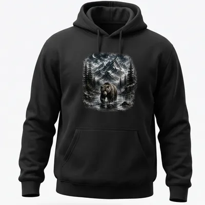 Realistic brown bear in a mountain wilderness scene with blue sky — printed on a unisex hoodie