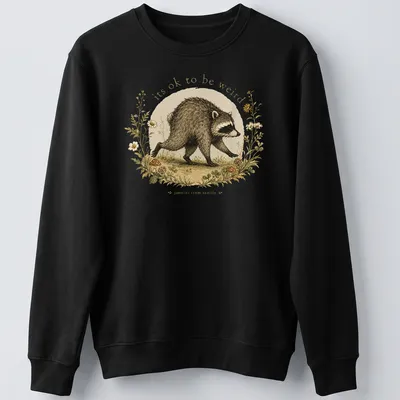 Cottagecore Raccoon t-shirt with whimsical design featuring the phrase about being weird — printed on a unisex sweatshirt