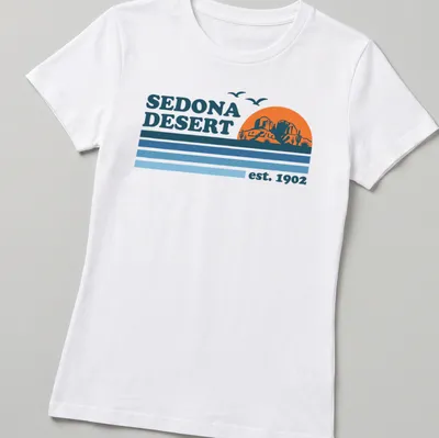 Vintage retro Sedona Desert T-shirt with mountains and cacti in orange and blue — printed on a women's shirt