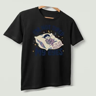 Kawaii illustration of a sleepy boy with a teddy bear and playful text — printed on a unisex t-shirt (angled view)