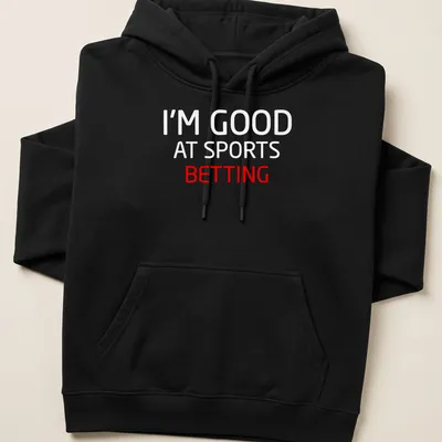 Bold typography t-shirt with the text I'm Good At Sports Betting in red and white — printed on a unisex hoodie