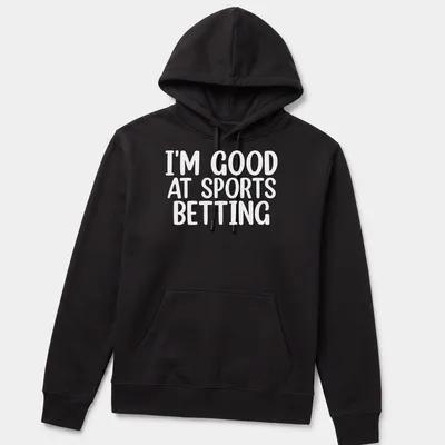 Bold typography states 'I'm Good At Sports Betting' in black on white. — printed on a unisex hoodie