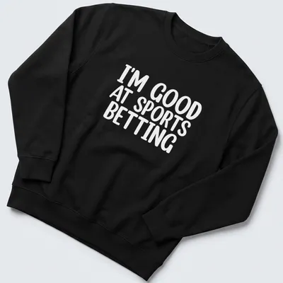 Bold typography states 'I'm Good At Sports Betting' in black on white. — printed on a unisex sweatshirt