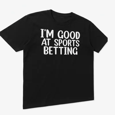 Bold typography states 'I'm Good At Sports Betting' in black on white. — printed on a unisex t-shirt (angled view)