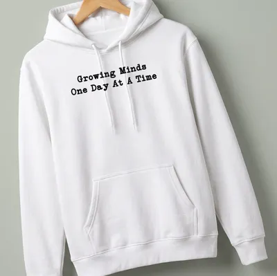 Bold typography Teacher shirt with the phrase Growing Minds One Day At A Time in black — printed on a unisex hoodie