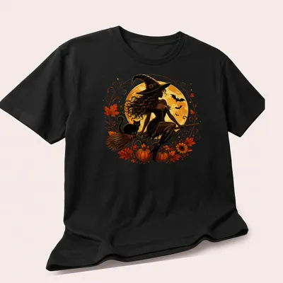 Illustrative Halloween shirt featuring a witch, black cat, moon, and pumpkins in colorful design — printed on a unisex t-shirt (angled view)
